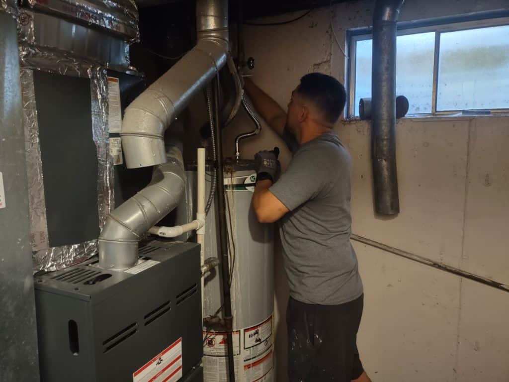 Armando replacing a water heater in a basement