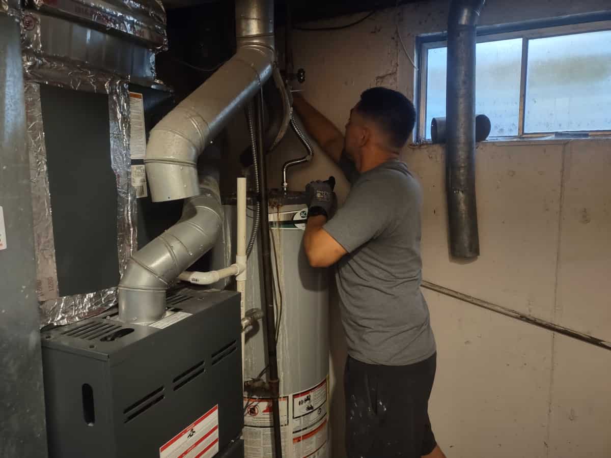 Armando replacing a water heater in a basement