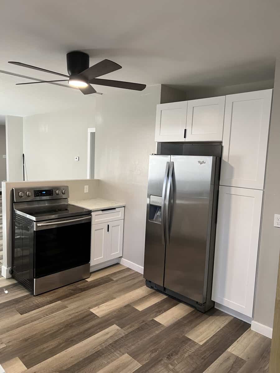 Remodeled Kitchen With Stainless Steel Appliances Remodeled Denver kitchen with white cabinets, new wood floor, and stainless steel fridge and oven
